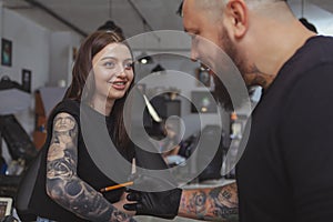 Young attractive woman getting new tattoo by professional tattooist