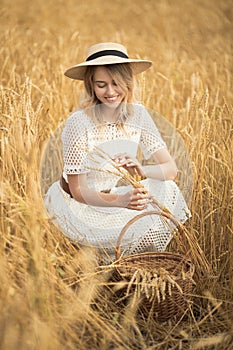 Young attractive woman and golden wheat field.