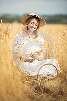 Young attractive woman and golden wheat field.