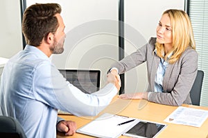 Young attractive woman handshaking at the end of a job interview