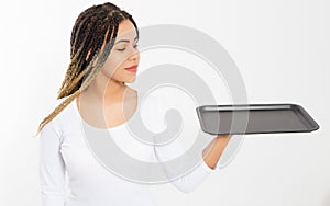 Young attractive woman holding empty pizza tray isolated on white background. Copy space and mock up. Blank template background.