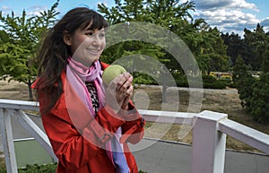 Young attractive woman holding green apple in her hands and smiling