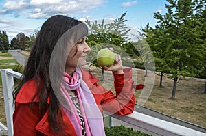 Young attractive woman holding green apple in her hands and smiling. Fresh food concept