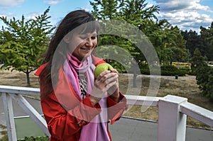 Young attractive woman holding green apple in her hands and smiling. Fresh food concept