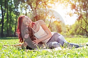 Young attractive woman hugs her dog in the park.