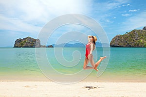 Young attractive woman jumping on the sea beach