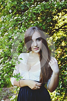 Young attractive woman in long dress in spring garden with bouquet of purple lilacs. Sunset light. Spring background. Internationa