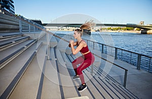 Young attractive woman makes High Intensity Intervall Training outdoor