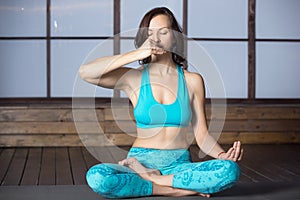 Young attractive woman making Alternate Nostril Breathing, studi photo