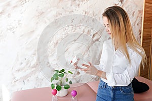 Young attractive woman in massage centre holding cosmetical jar