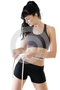 Young attractive woman measuring her hips with tape measure