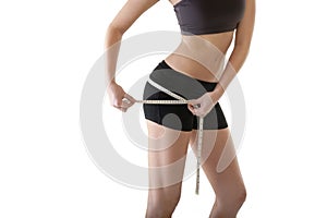 Young attractive woman measuring her hips with tape measure