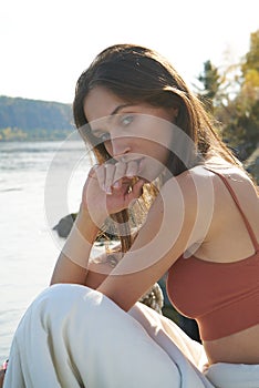 A young attractive woman of model appearance rests under a blanket on a pier. long hair