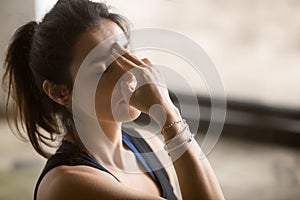 Young attractive woman in nadi shodhana pranayama pose, studio b