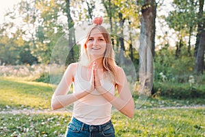 Young attractive woman outdoor holding red apple on her head and thinking about something on the blur nature background