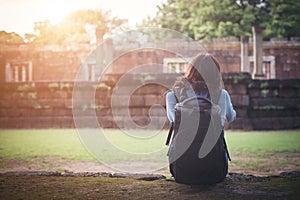 Young attractive woman photographer tourist with backpack coming