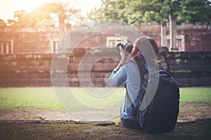 Young attractive woman photographer tourist with backpack coming