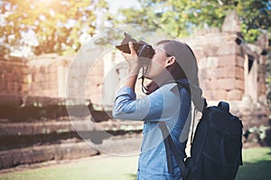 Young attractive woman photographer tourist with backpack coming