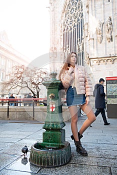 Young attractive woman posing near Milan Cathedral, Italy. Beautiful girl walking Milanese streets