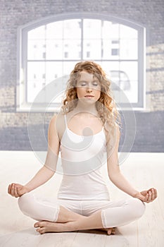 Young attractive woman practicing yoga meditating