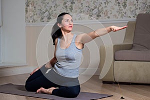 Young attractive woman practicing yoga, wearing sportswear, meditation session, home interior