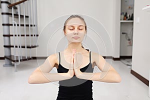 Young attractive woman practicing yoga, yoga studio. quarantine sports. Woman training and practicing yoga at class. Girl doing