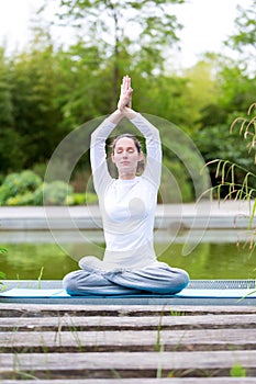 Young attractive woman practising yoga in a park