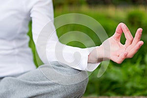 Young attractive woman practising yoga in a park