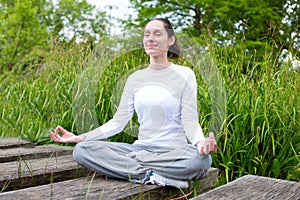 Young attractive woman practising yoga in a park