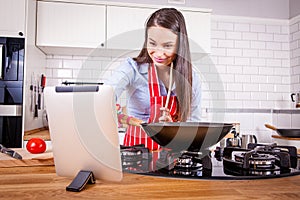 Young attractive woman reading recipe in kitchen.