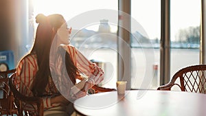 Young attractive woman in red sunglasses with tablet computer sitting in cafe. Beautiful girl in airport or shoppping