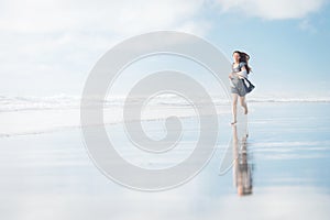 Young attractive woman running at amazing New Zealand beach