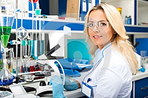 Young attractive woman scientist researching in the laboratory photo