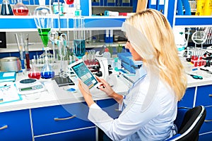 Young attractive woman scientist using tablet computer in the la