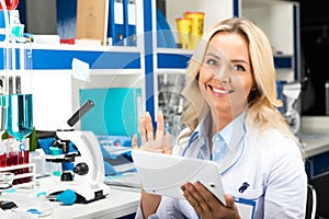 Young attractive woman scientist using tablet computer in the la