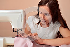 Young attractive woman sewing