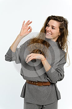 Young attractive woman showing OK gesture. Long curly hair