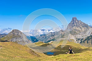 Young Attractive Woman sitting resting in a Beautiful wild mountain Landscape in summer. Discovery Travel Destination