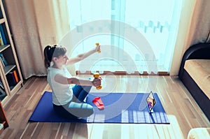 Young attractive woman in sports clothing doing workout at home