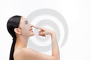 Young attractive woman touching her nose with fingertip over isolated white background
