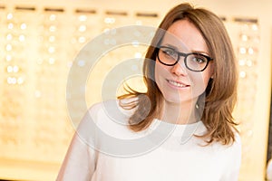 Young attractive woman trying glasses at the optician