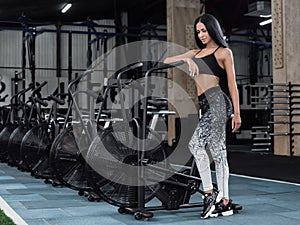 Young, attractive woman using exercise bike at the gym. Fitness