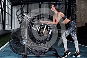 Young, attractive woman using exercise bike at the gym.