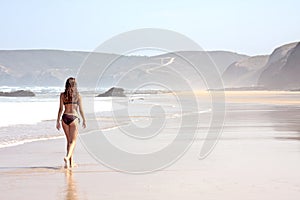 Young attractive woman walking on the beach