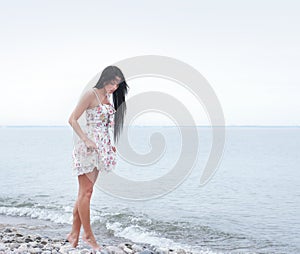 A young and attractive woman walking near the sea