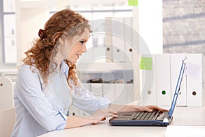 Young attractive woman working on laptop in office