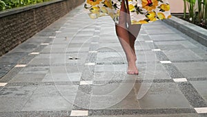 Young attractive woman in a yellow dress is dancing in a park. female legs in latya closeup