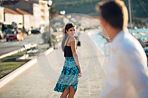 Young attractive woman flirting with a man on the street.Flirty smiling woman looking back on a handsome man.Female attraction photo