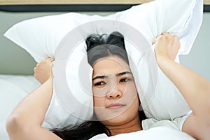 Young attrative Asian woman on white pillow and bed sheet in bedroom