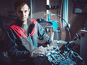 The young auto mechanic dismantles the opposing engine.